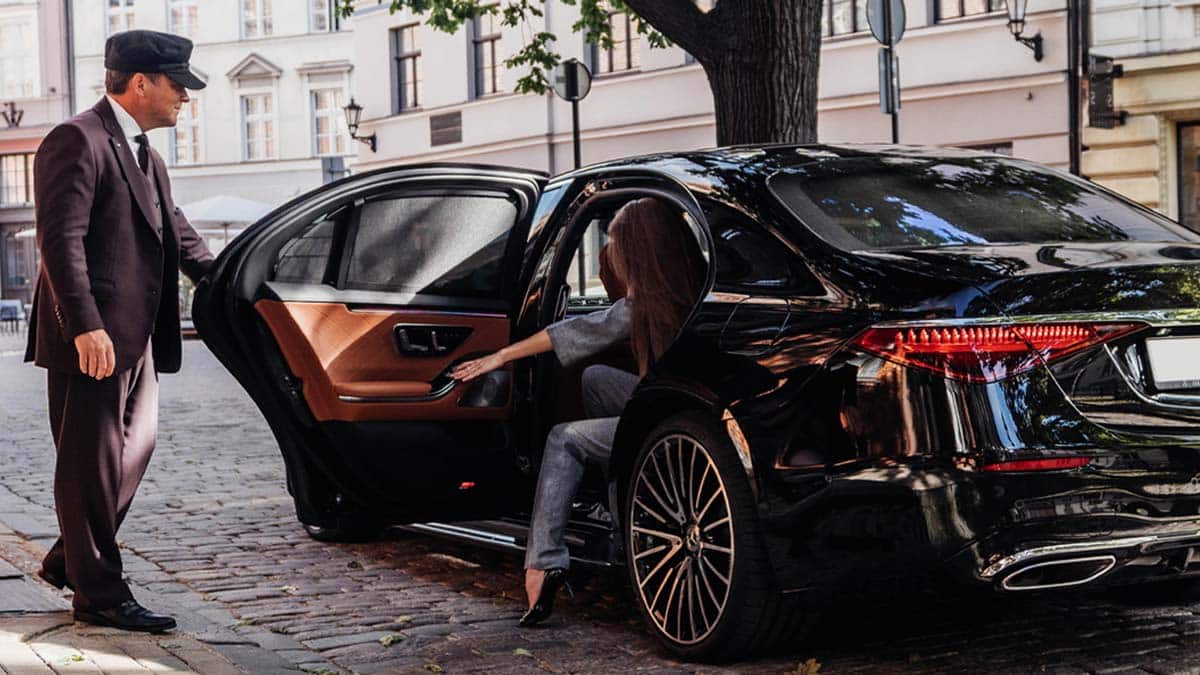chauffeur opening luxury mercedes s-class door